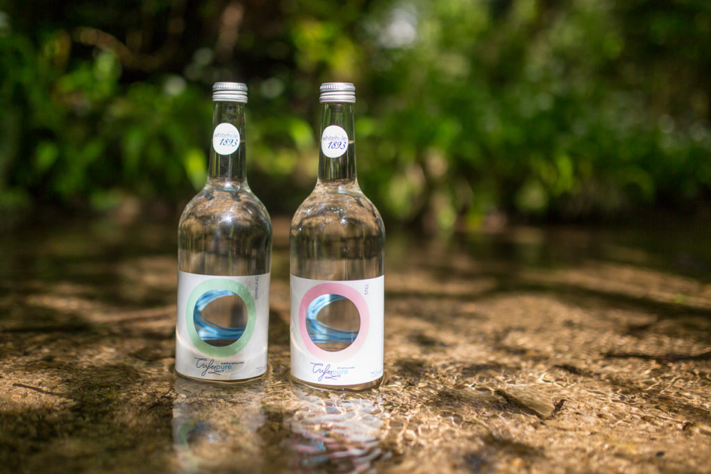 Two bottles of mineral water standing in cool shallow stream